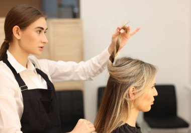 Kuaför müşterisiyle kuaförde çalışıyor.