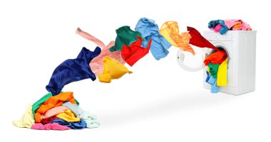 Çamaşır makinesi ve beyaz arka planda uçan çamaşırlar.