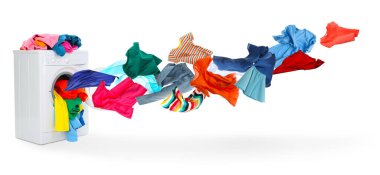 Çamaşır makinesi ve beyaz arka planda uçan çamaşırlar.