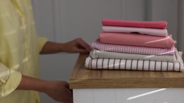 Kadın giysileri kapalı dolaba koyuyor, yakın plan.