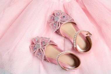 Bir çift şık çocuk ayakkabısı ve eteği, üst manzara.