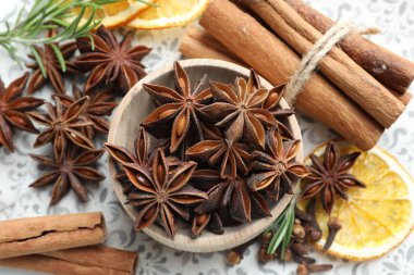 Farklı baharatlar, kuru portakal dilimleri ve taze biberiye.