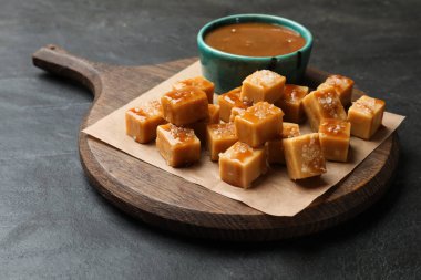 Koyu dokulu masada tuz ve karamel soslu lezzetli şekerler, yakın plan.