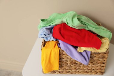 İçerideki bej duvarın yanındaki beyaz masada çamaşır sepeti, yakın plan. Metin için boşluk