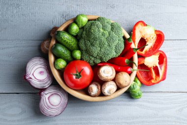 Gri ahşap masada farklı taze taze sebzeler, düz yatıyordu.