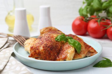 Lezzetli kızarmış tavuk butları ve fesleğenli beyaz fayanslı masa, yakın çekim.