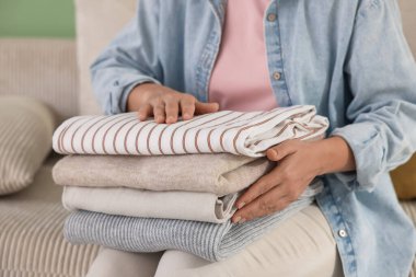 İçerideki koltukta bir yığın elbisesi olan kadın, yakın plan.