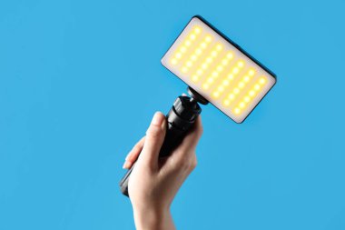 Açık mavi arka planda parlayan LED lambalı kadın, yakın plan. Metin için boşluk