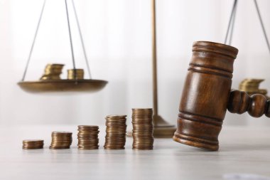 Nafaka. Hakimin tokmağı, madeni paralar ve teraziler ahşap masada, yakın plan.