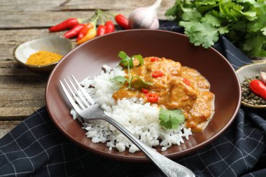 Pirinçli tavuk tikka masala, ahşap masada servis edilir, yakın plan.