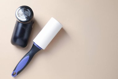 Bej arka planda pamuk tutacağı ve kumaş traş makinesi, düz konum. Metin için boşluk