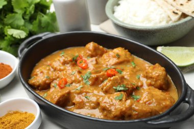 Tavuk tikka masala, pirinç ve baharatlar beyaz masada, yakın plan.