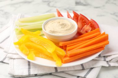 Farklı taze sebzeler ve soslar beyaz mermer masada, yakın plan.