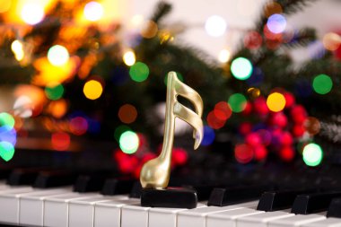 Altın müzik notası ve piyanoda Noel dekoru, yakın plan.