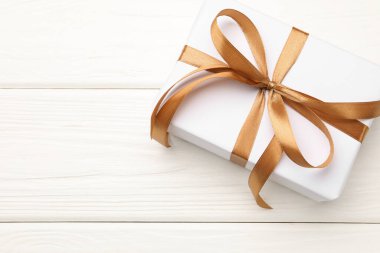 Beyaz ahşap arka planda güzel bir hediye kutusu, üst manzara. Metin için boşluk