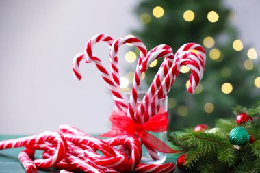 Şeker kamışları ve Noel dekoru yeşil ahşap masada bulanık ışıklara karşı