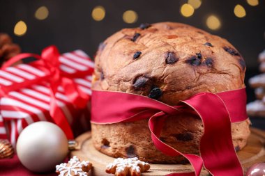 Noel yemeği. Lezzetli Panettone keki, zencefilli kurabiye ve bulanık ışıklara karşı masanın üstünde dekor, yakın plan. Bokeh etkisi