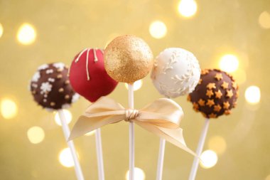 Bej arka planda, bulanık ışıkları olan lezzetli pastalar, yakın plan. Noel hediyesi