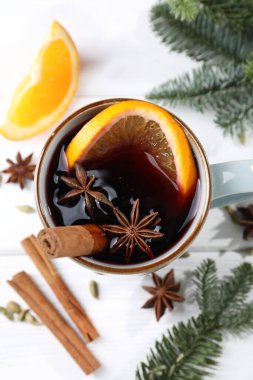 Lezzetli şaraplar, baharatlar ve köknar dalları beyaz masada, düz yerde.