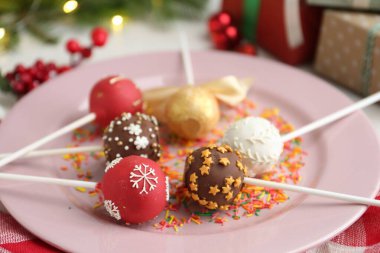 Tatlı kek parçaları ve Noel süsü ile masada, yakın plan.