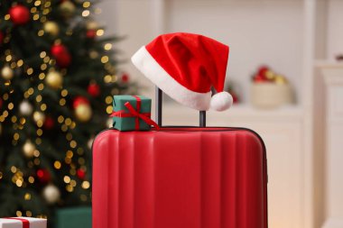 Noel tatili. İçinde Noel Baba şapkası ve hediye kutusu olan bavul, kapalı.