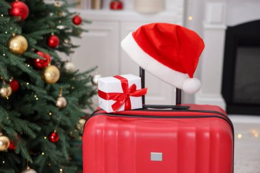 Noel tatili. İçinde Noel Baba şapkası ve hediye kutusu olan bavul, kapalı.
