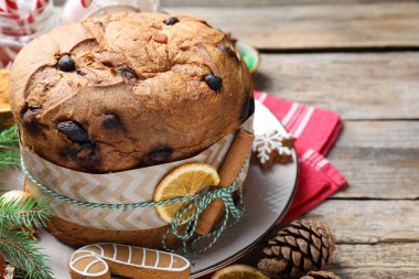 Tarçın çubuğu ve ahşap masada kuru portakal dilimiyle süslenmiş leziz bir Noel pastası. Yakın plan. Metin için boşluk