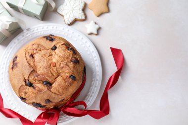Lezzetli Noel panettonlu pasta, zencefilli kurabiye ve bej masadaki hediyeler, düz yatak. Metin için boşluk