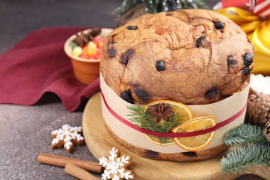 Baharatlı panettone keki, şekerli meyveler ve kahverengi masada Noel süsü, yakın plan. Metin için boşluk