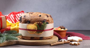 Baharatlı panettone keki, şekerli meyveler ve kahverengi masa üzerindeki Noel süsü, yakın plan.