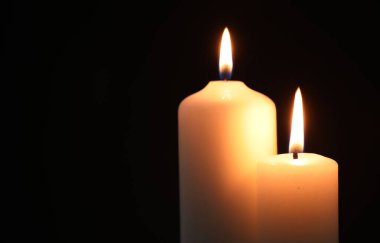 Siyah arka planda yanan güzel mumlar, yakın plan. Metin için boşluk