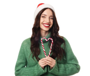Beyaz arka planda Noel Baba şapkası ve baston şekerleri olan güzel bir kadın. Noel sezonu