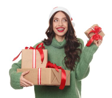 Mutlu kadın Noel Baba şapkası takıyor ve beyaz arka planda hediyeler var.