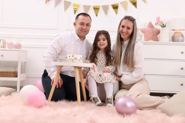 Doğum günü kutlaması. Mutlu aile portresi ve evde lezzetli bir pasta.