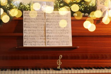 Müzik kağıtları, not ve piyanoda Noel dekoru. Bokeh etkisi