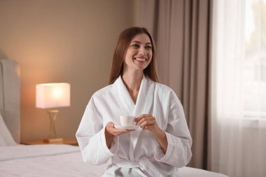 Sabahları evde kahve içen bornozlu güzel bir kadın. Metin için boşluk