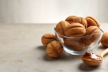 Lezzetli fındık şekilli kurabiyeler haşlanmış süt ve kaşıkla hafif desenli masa, yakın çekim. Metin için boşluk