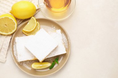 Nane, taze meyve ve bej masadaki çay ile lezzetli limonlu barlar, düz yatak. Metin için boşluk