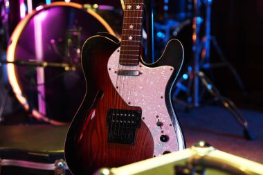 Modern elektro gitar ve davul takımı sahnede, yakın plan.