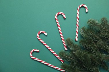 Yeşil arka planda şeker kamışlı düz kompozisyon, metin için boşluk. Noel hediyesi