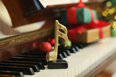 Noel atmosferi. Piyanoda altın müzik notası, yakın plan. Bokeh etkisi