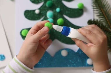 Küçük çocuk Noel kartpostalı hazırlıyor. Çocuk el yapımı.