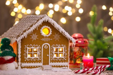 Güzel zencefilli kurabiye evi ve Noel dekoru bulanık ışıklara karşı, yakın plan