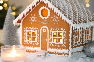 Güzel zencefilli kurabiye evi ve Noel dekoru bulanık ışıklara karşı, yakın plan. Bokeh etkisi