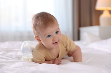 Evde yatağında biberonla beslenen tatlı bir bebek. Metin için boşluk