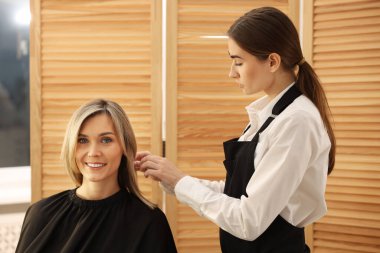 Kuaför müşterisiyle kuaförde çalışıyor.