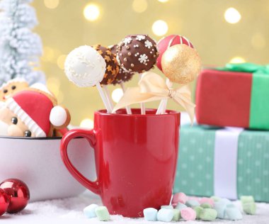 Lezzetli kek kupada, şekerlemelerde, zencefilli kurabiyelerde ve bej arka planda bulanık ışıklarla Noel dekorunda.