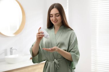 Evde pudra gibi pudra kullanan bir kadın.