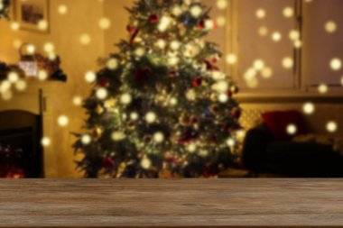 Boş ahşap masa, bulanık odaya karşı, Noel ağacı ve ışık var. Tasarım için boşluk