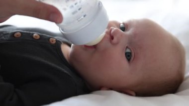 Anne bebeğini şişeyle besliyor.